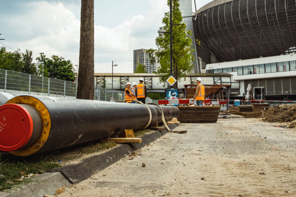 2 grote buizen op de grond met de Arena op de achtergrond