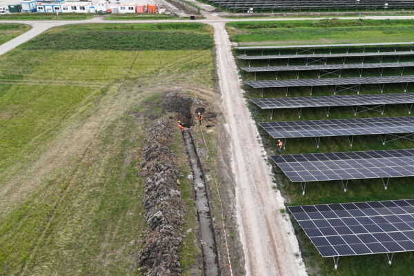 2 medewerkers in een gat in een veld met zonnepanelen voor het bedrijf WATT